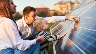 homme montre panneaux solaires a sa famille
