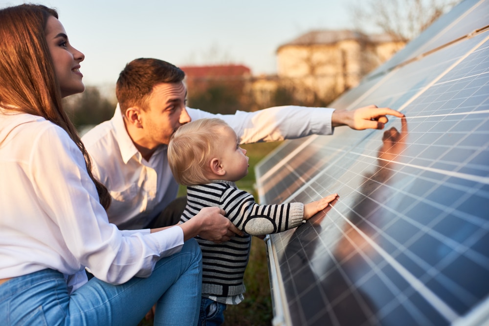 homme montre panneaux solaires a sa famille